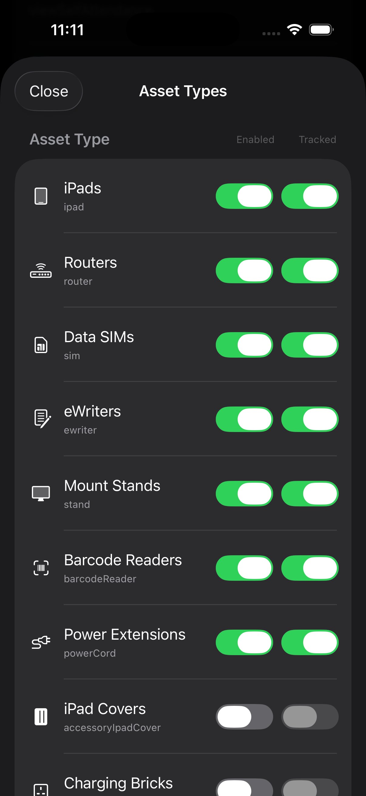 Asset Types modal listing iPads, Routers, Data SIMs, eWriters, Mount Stands, Barcode Readers, Power Extensions, iPad Covers, Charging Bricks with Enabled and Tracked toggle columns. Most are Enabled+Tracked; iPad Covers is disabled